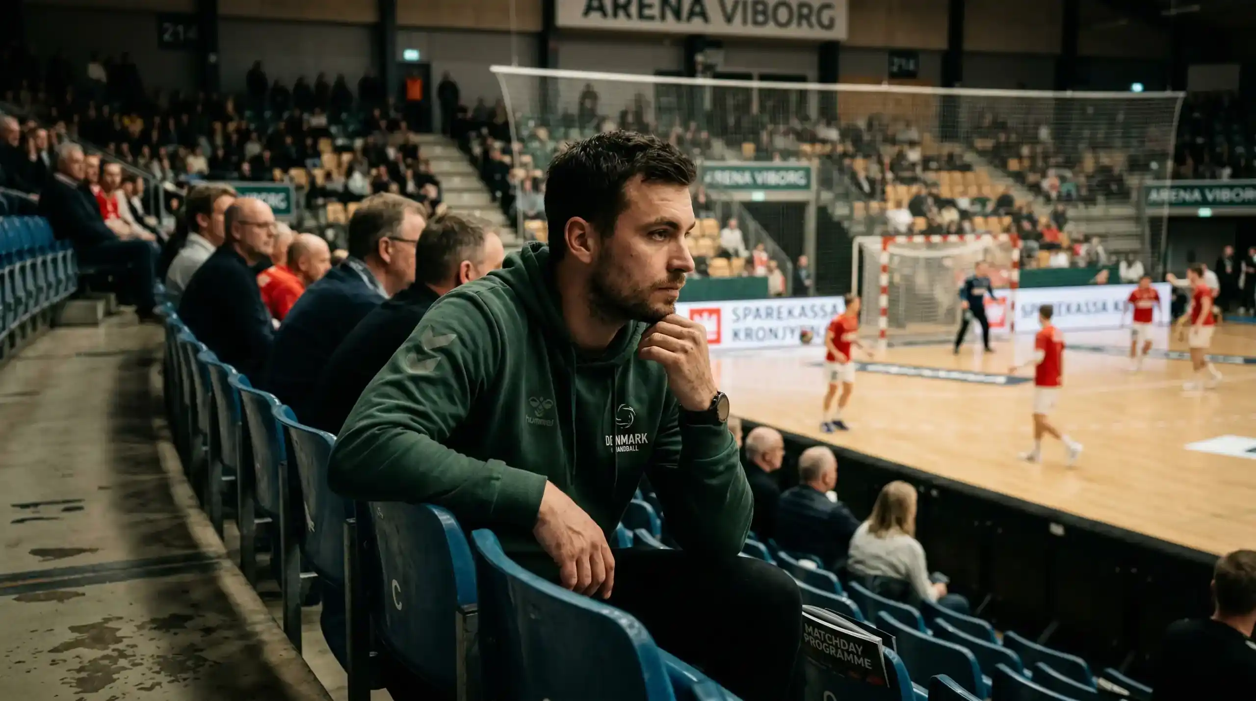 Nachdenklicher Handball-Fan blickt auf das Spielfeld